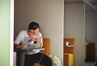 Frustrated remote worker sitting in front of laptop