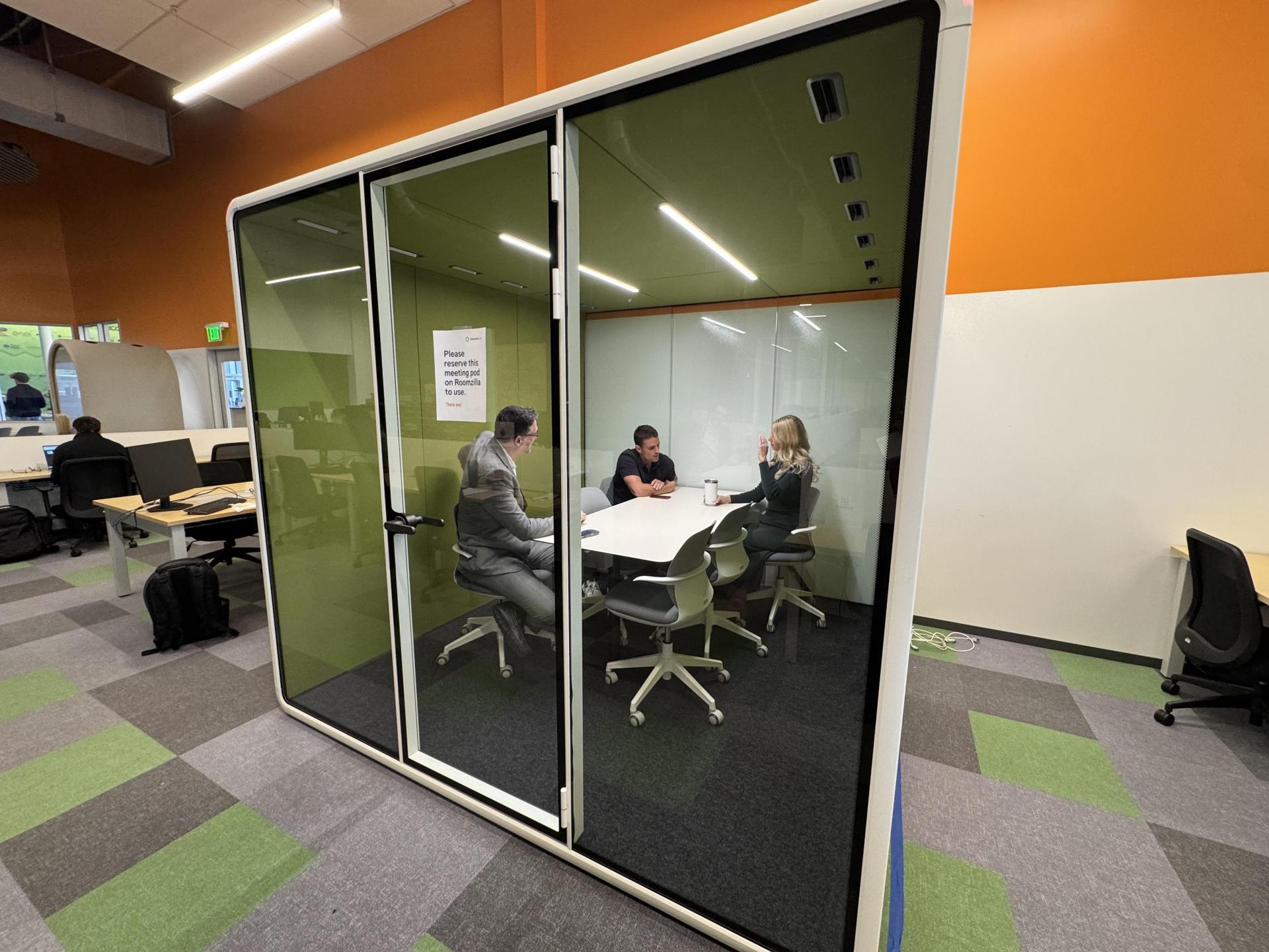 Three people sitting in modular office space