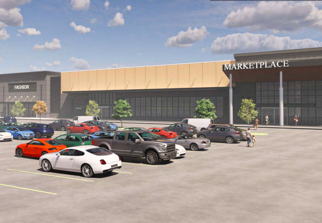A busy mall parking lot with various cars parked in front of a large shopping complex labeled "Marketplace" under a partly cloudy sky.