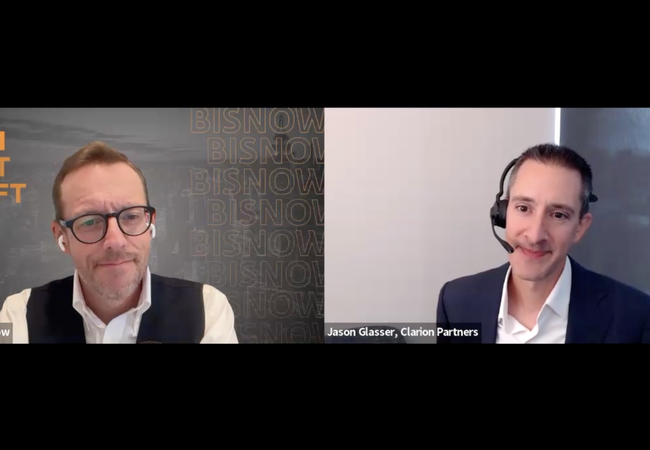Two men in a virtual meeting, one with glasses and earphones, the other wearing a headset. Text: "BISNOW FIRST DRAFT LIVE."