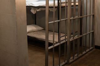 An empty jail cell with two bunks.