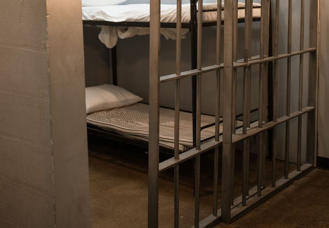An empty jail cell with two bunks.
