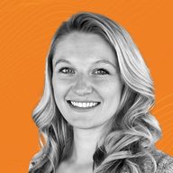 Portrait of a smiling woman with long, wavy hair against an orange background with subtle patterns.