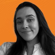 A woman with long hair smiles slightly in a black and white photo against an orange background. She wears a white top.