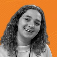 Smiling woman with curly hair against an orange wavy patterned background.