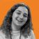 Smiling woman with curly hair against an orange wavy patterned background.