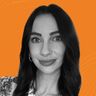 A black and white portrait of a woman with long dark hair, against an orange background with subtle wave patterns.