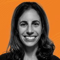 Smiling woman with long dark hair against an orange, textured background.