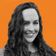 A woman with long curly hair smiles against an orange background with wavy lines.