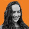A woman with long curly hair smiles against an orange background with wavy lines.