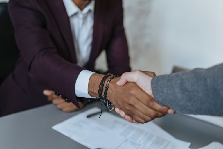 Two professional people shaking hands over an agreement.