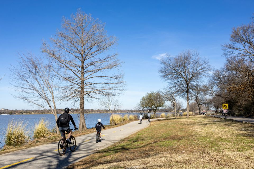 People riding on a trail around White Rock Lake.