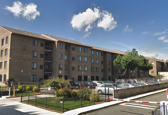 The Washington Apartments at 1205 7th St. NW in Shaw, a four-story community with a surface parking lot. 