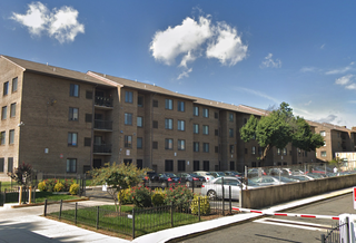 The Washington Apartments at 1205 7th St. NW in Shaw, a four-story community with a surface parking lot. 