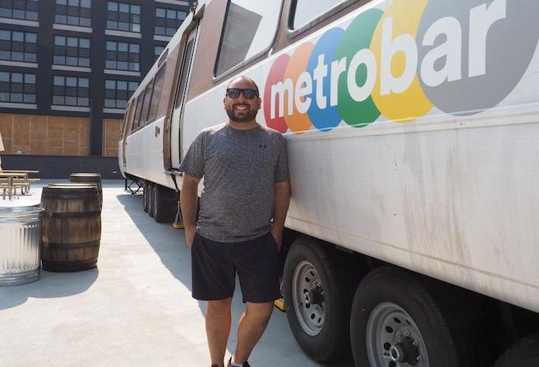 Metrobar owner Jesse Rauch standing next to the Metro car at his new outdoor bar at Bryant Street. 