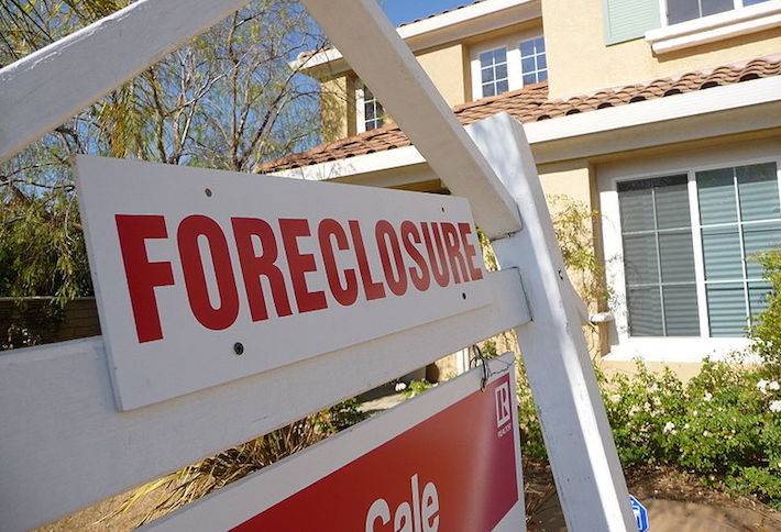 A foreclosure sign in front of a building.