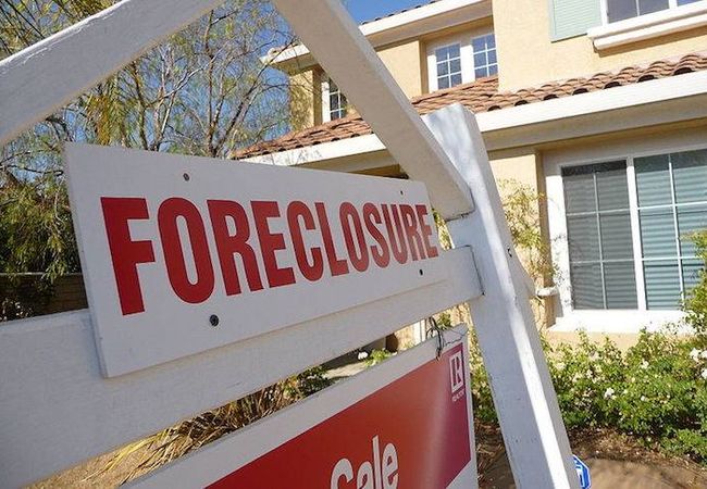 A foreclosure sign in front of a building.