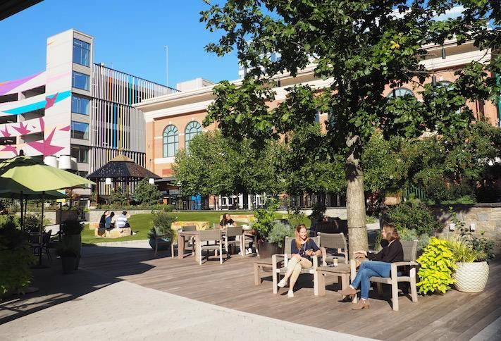 People sitting outside in park at the Pike & Rose development. 