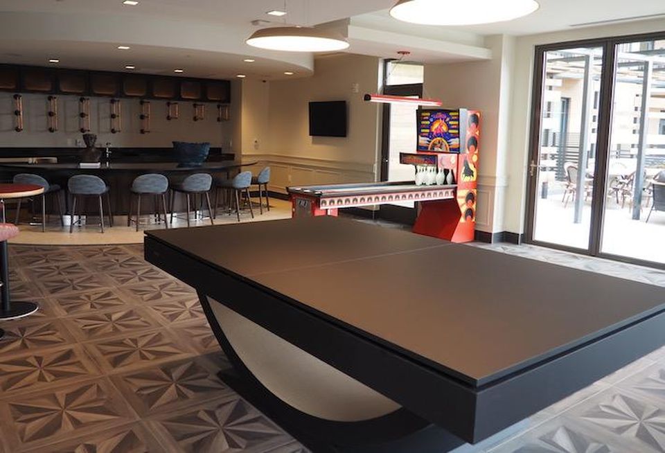 The clubroom on the second floor of the Avec building, with a door to an outdoor amenity space.