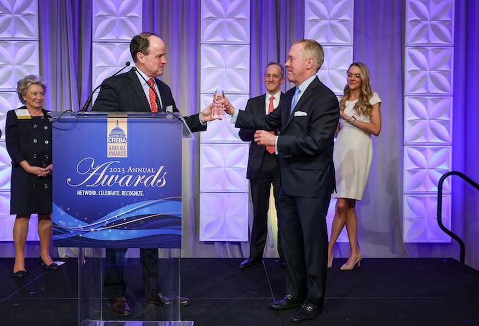 Transwestern's Phil McCarthy accepting the Joseph Stettinius Jr. Leadership Award from Transwestern's Keith Foery at CREBA's awards ceremony Tuesday evening.