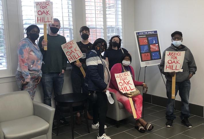 Members of the Oak Hill Tenants Association and organizers waiting in the lobby of the 4910 Massachusetts Ave. NW office building after their apartment community sold at auction. 