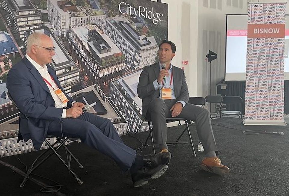 Roadside Development's Richard Lake and Wegmans' Dan Aken speak during a keynote at Bisnow's Northwest D.C. event on June 2, 2022.