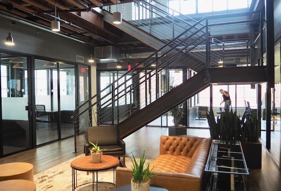 A lounge area and interior staircase in coworking space The Mark at the Wonder Bread Factory building.