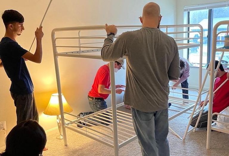 Volunteers with Homes not Borders setting up beds for an Afghan refugee family. 