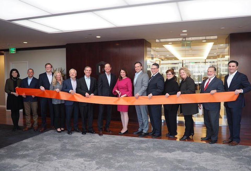 Goodwin cutting the ribbon in the 10th story lobby of its its new office