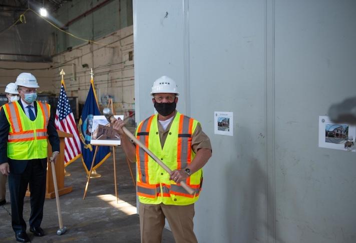 Chief of Naval Operations Adm. Mike Gilday broke drywall with a sledge hammer during the groundbreaking ceremony for the Operational Archives and Repository Complex at the Washington Navy Yard. 