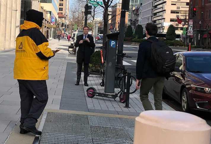 A Golden Triangle BID ambassador hands out leaflets on working conditions on Thursday, March 10.