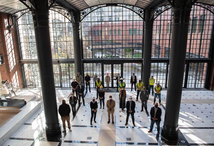 The Donatelli-Blue Skye development team and D.C. officials in the grand atrium of the new Park Kennedy building in Hill East. 