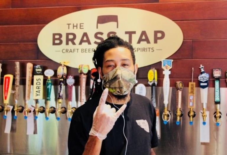 A bartender wearing a mask and gloves at The Brass Tap in National Harbor. 