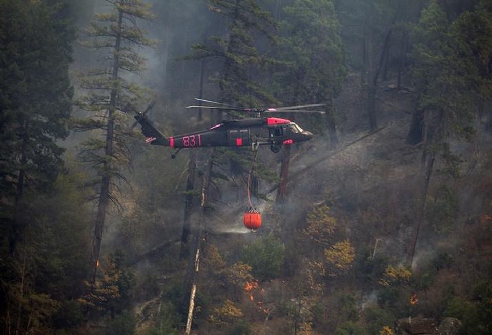 National Guard members fly through Feather River Canyon to drop water on the Camp Fire.