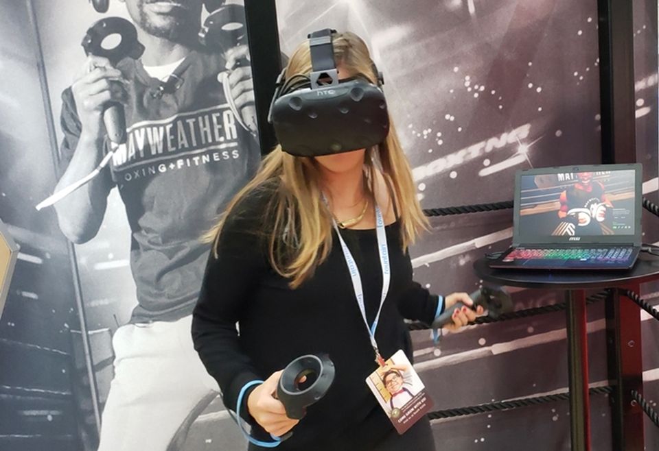 An attendee faces off against a virtual Floyd Mayweather Jr. at the Mayweather Boxing + Fitness booth at the Franchise West Expo in Los Angeles