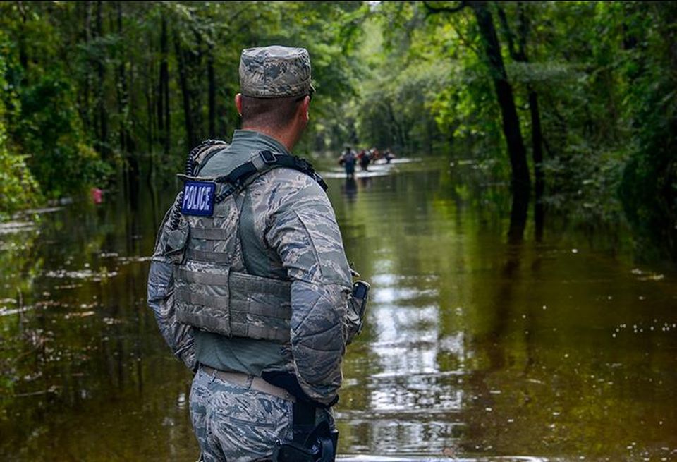 A U.S. Air Force Security Forces Airmen assigned to the South Carolina Air National Guard, 169th Fighter Wing, from McEntire Joint National Guard Base, working alongside Florence County, S.C., Sheriff’s Department watches as citizens walk through a flooded road during evacuation efforts as the Black Creek river begins to crest in Florence, S.C., Sept. 17, 2018.