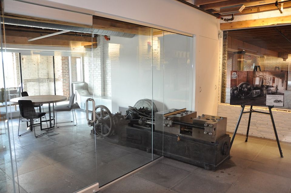 The rag baler was too heavy to move, so the developer incorporated it into a conference room.