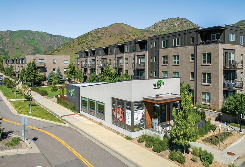 A high-resolution photo of the West 8th apartments in Golden, with green mountains as a backdrop.