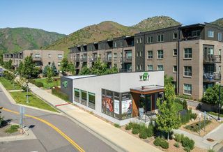 A high-resolution photo of the West 8th apartments in Golden, with green mountains as a backdrop.