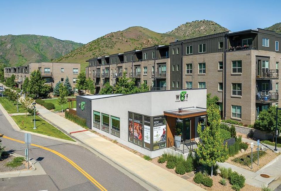 A high-resolution photo of the West 8th apartments in Golden, with green mountains as a backdrop.