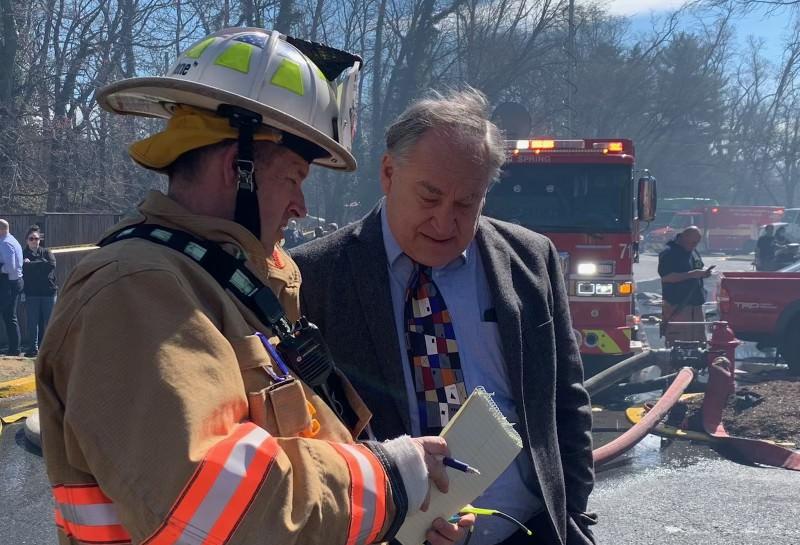 County Executive Marc Elrich speaks to a firefighter at the scene of the fire at Friendly Garden Apartments.