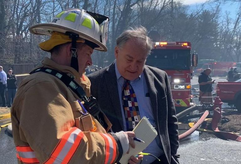 County Executive Marc Elrich speaks to a firefighter at the scene of the fire at Friendly Garden Apartments.