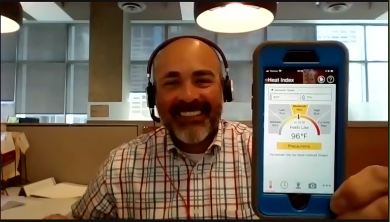 Skanska Environmental Health Safety Director Carlos Alvarez holds up the heat index app that Skanska uses to track the heat on work sites. 