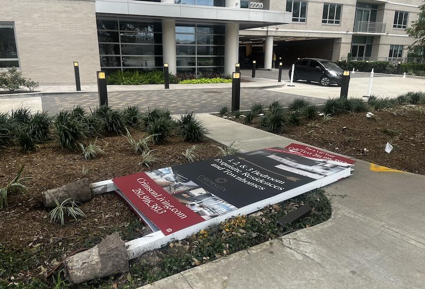 A sign advertising luxury apartments lies toppled on Monday, a week after Hurricane Beryl hit Houston.