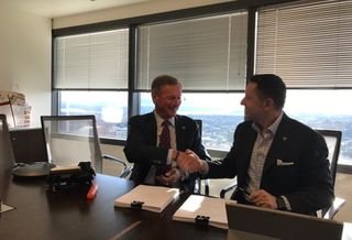Jeff Lyon and Robert Thornburgh, signing to merge Heger/Kidder Mathews