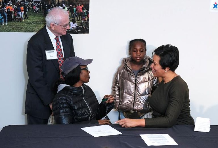 E&G Group's Tom Gallagher (left) with Mayor Muriel Bowser (right) and tenants at the Meadow Green Courts property. 