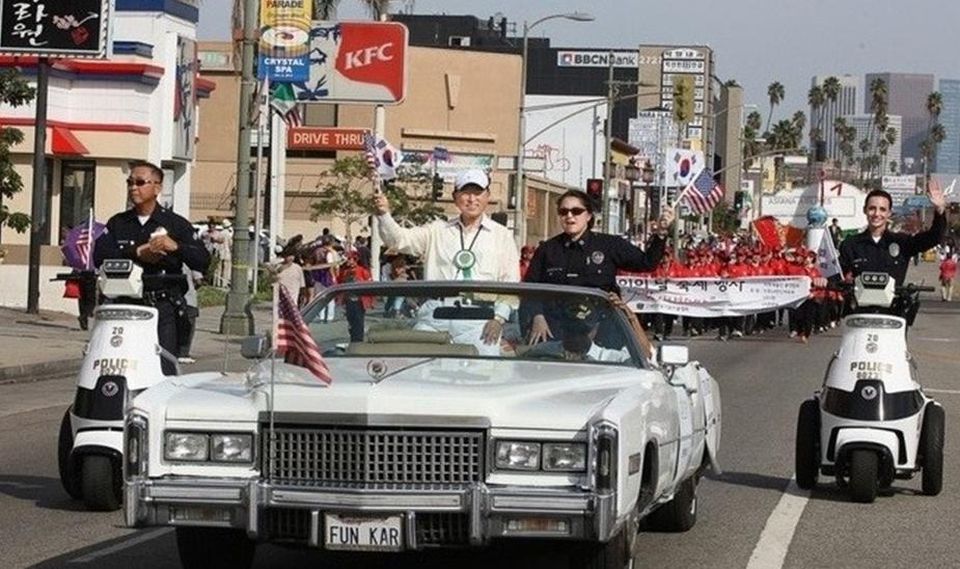 Festival founder Gene Kim's open car parade with Capt. Tina Nieto, Olympic Police Station.