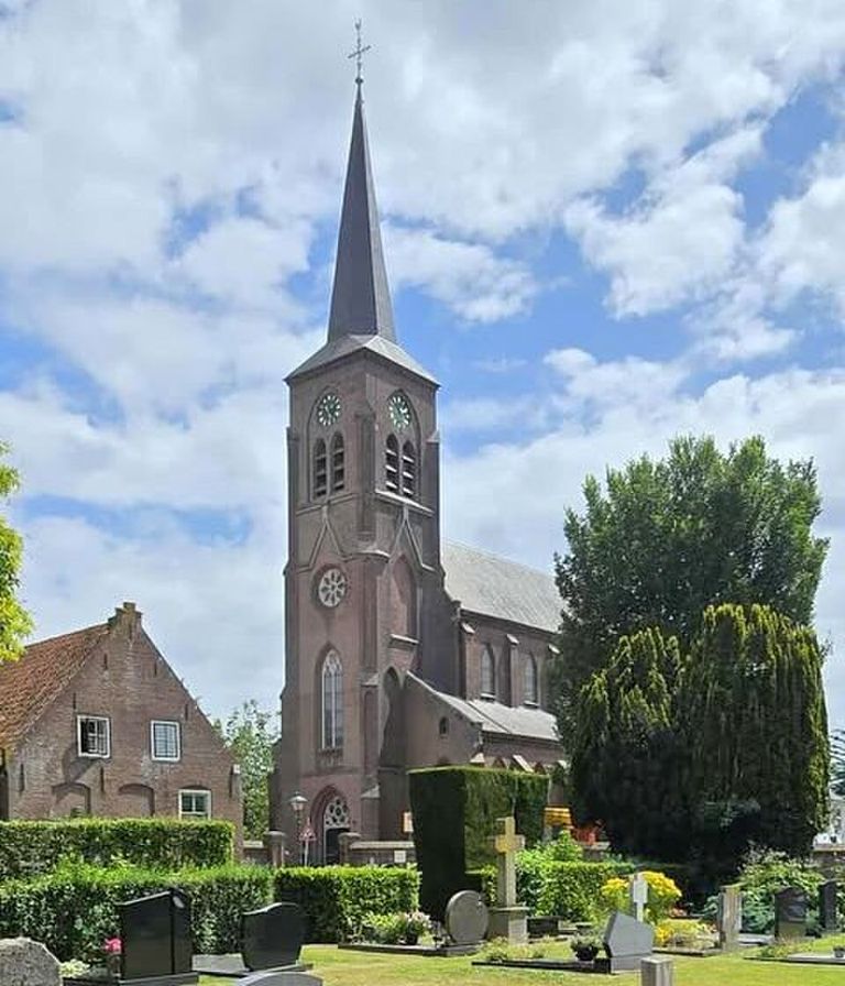 A tall church with a pointed spire, surrounded by trees and gravestones, under a partly cloudy sky.