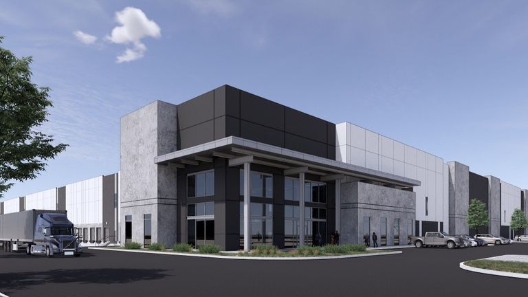 Modern industrial warehouse with glass entry, large truck parked on the left, and several cars parked on the right under a clear blue sky.
