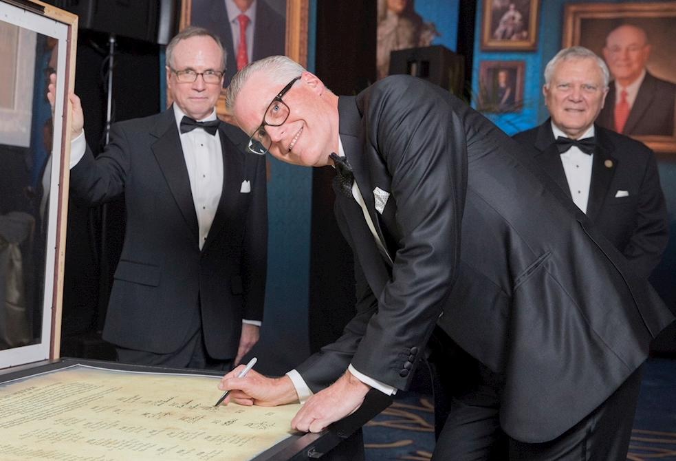 Delta CEO Ed Bastian adds his name to the Georgia Trustees as Georgia Historical Society President Todd Groce and Georgia Gov. Nathan Deal look on.